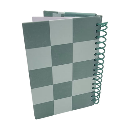 A "Ho ho ho notebook" featuring a green checkered design with a partially open cover.