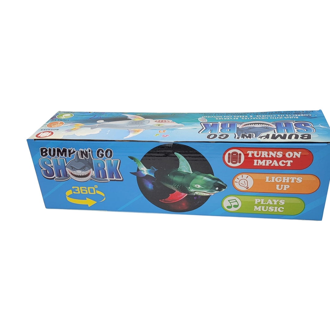 Box packaging for the "Bump n Go Shark" toy features its ability to turn upon impact, light up, and play music.