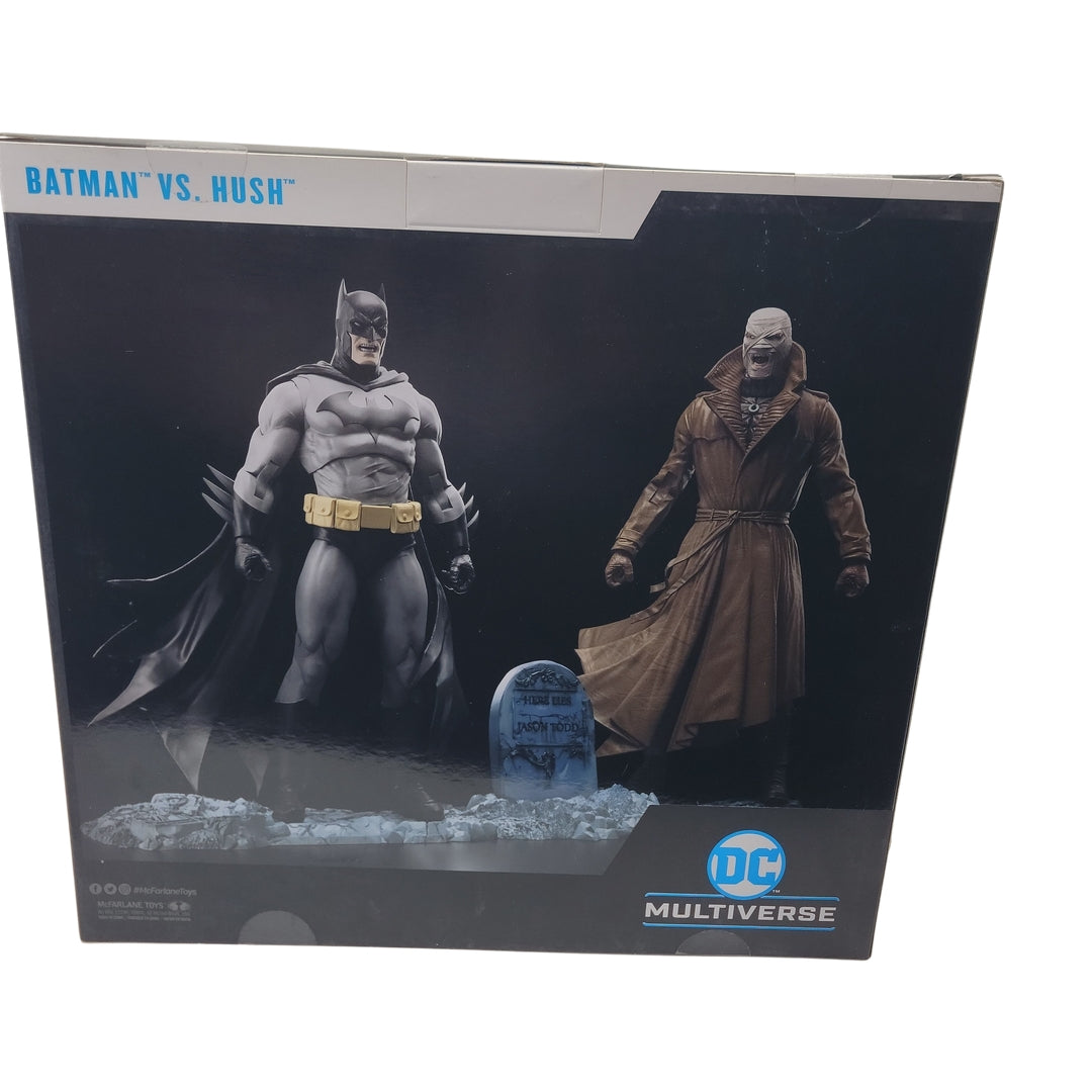 Box featuring the Multiverse Batman VS Hush action figures: Batman dressed in a black cape and Hush wearing a brown trench coat, complete with a gravestone accessory.