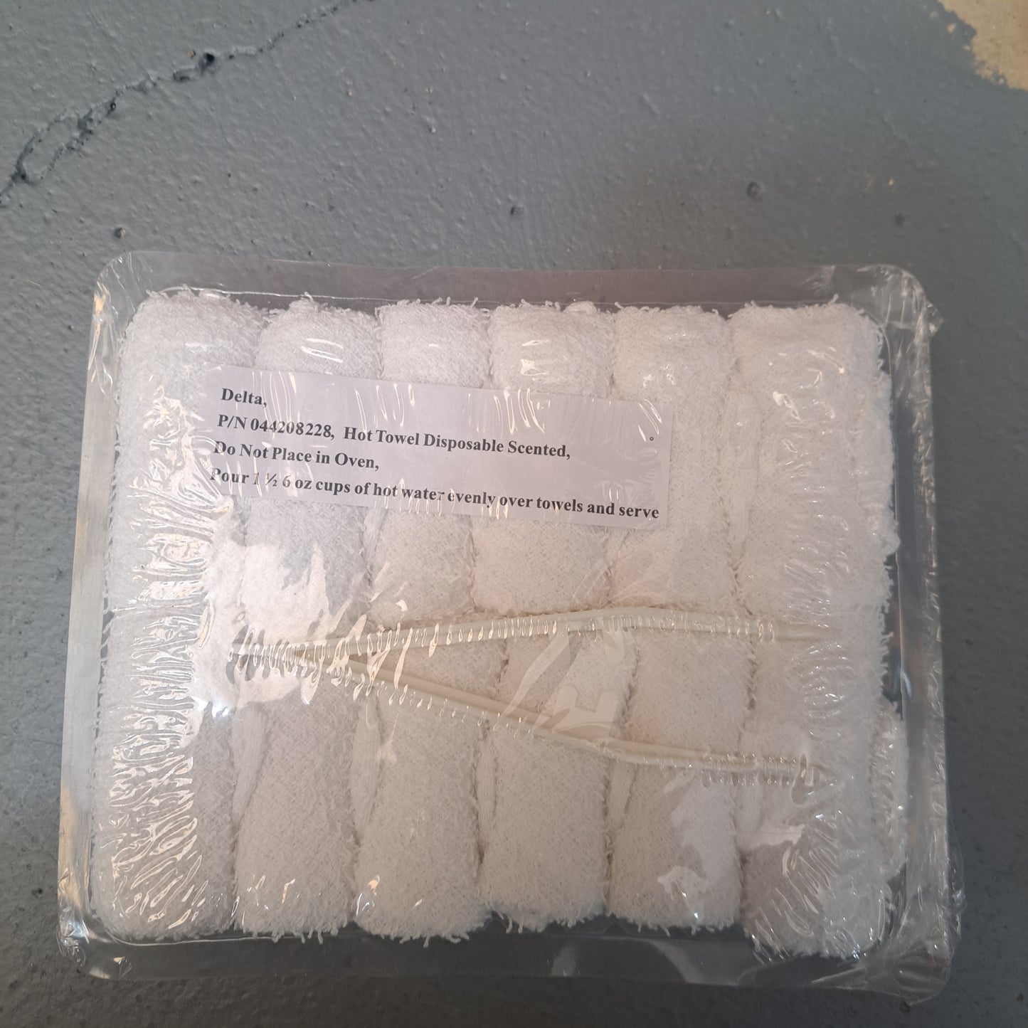 A package of 12 disposable towels with instructions: "Do not place in oven. Pour 16 oz cups of hot water evenly over these highly absorbent towels and serve.