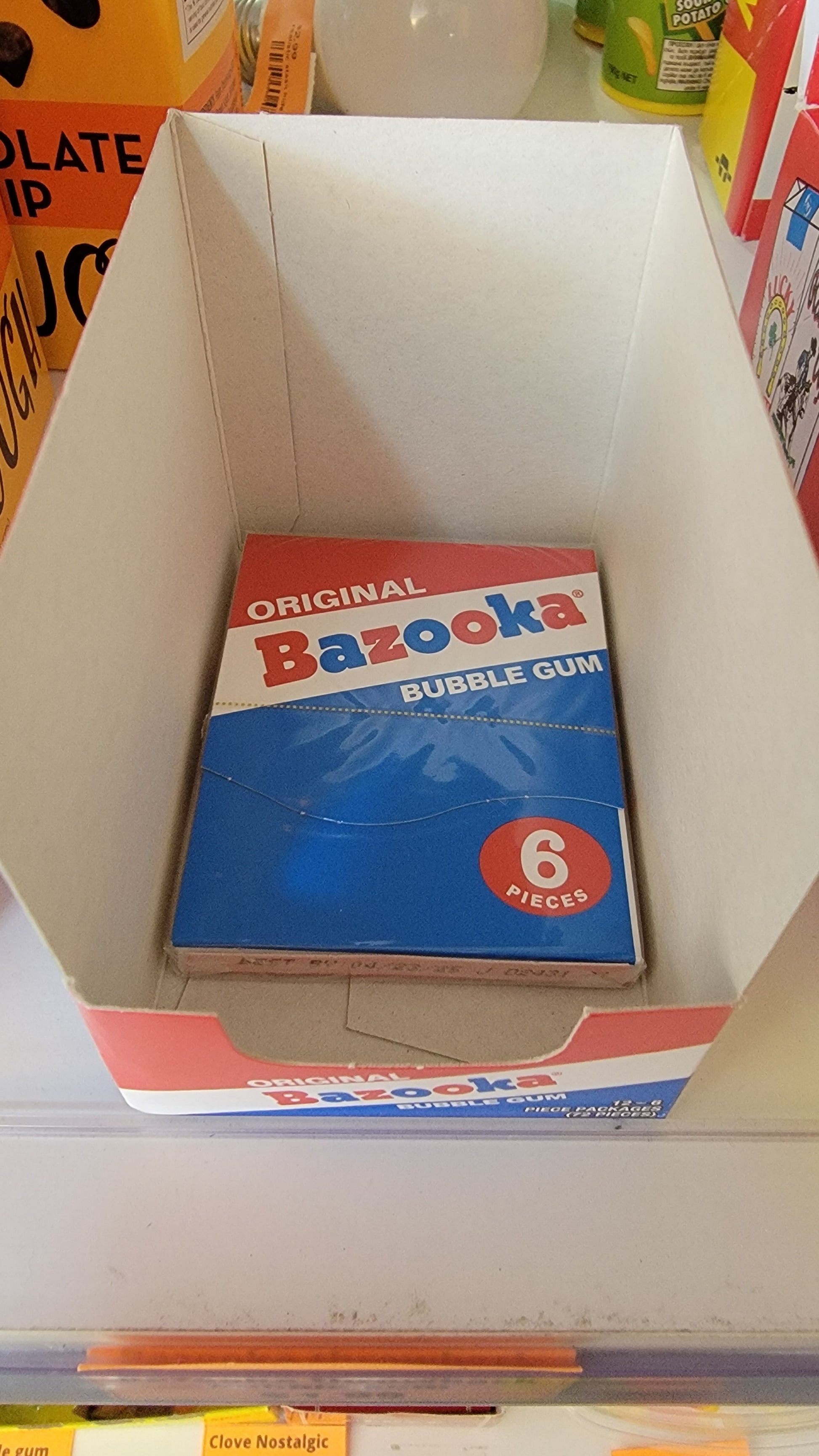 Bazooka Throwback Bubble Gum Wallet with 6 pieces displayed in an open cardboard box on a grocery shelf.