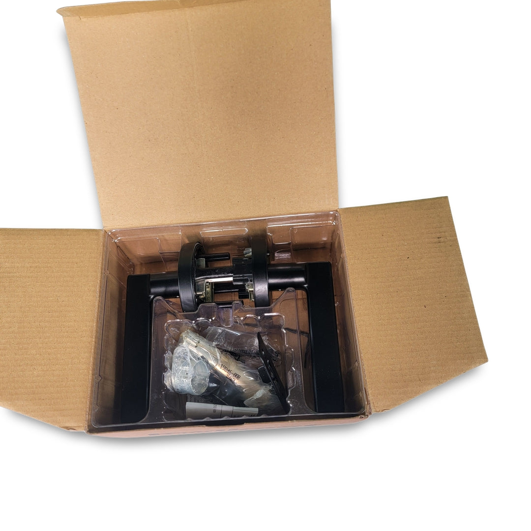 A matte black open cardboard box contains a Kwikset Halifax Privacy door lever and its wrapped components.