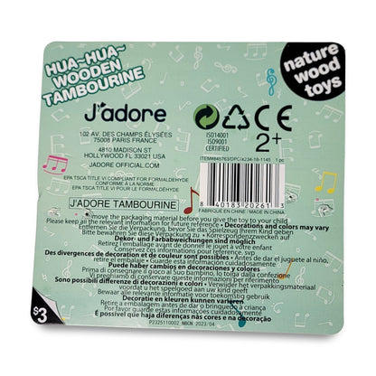 The back of the J' adore wooden Tambourine toy features brand details, safety certifications, an age recommendation of 2+, and a price of $3, with a design including musical notes and pastel colors.